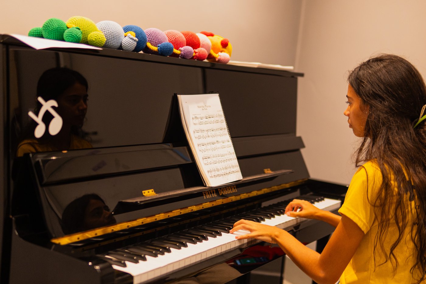 Aluna tocando piano na Escola de Música Holanda Premium em Goiânia